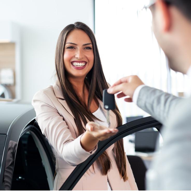 微笑的汽车推销员递上你的新车钥匙快乐的女孩的画面